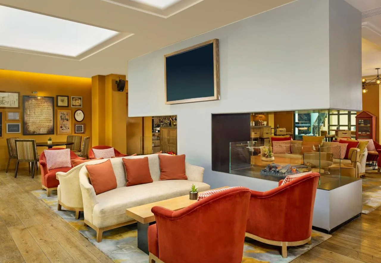 a lobby with couches and chairs and a tv at Hyatt Regency Birmingham in Birmingham